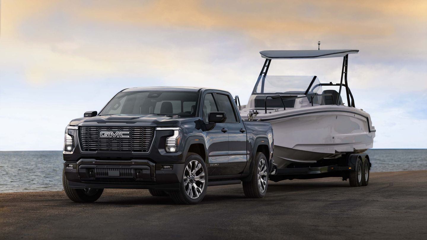 2027 GMC Sierra - front angle view of a dark grey 2027 GMC Sierra Denali towing a boat near the water - Humberview Chevrolet, Buick, GMC - New car dealership in Toronto, Ontario