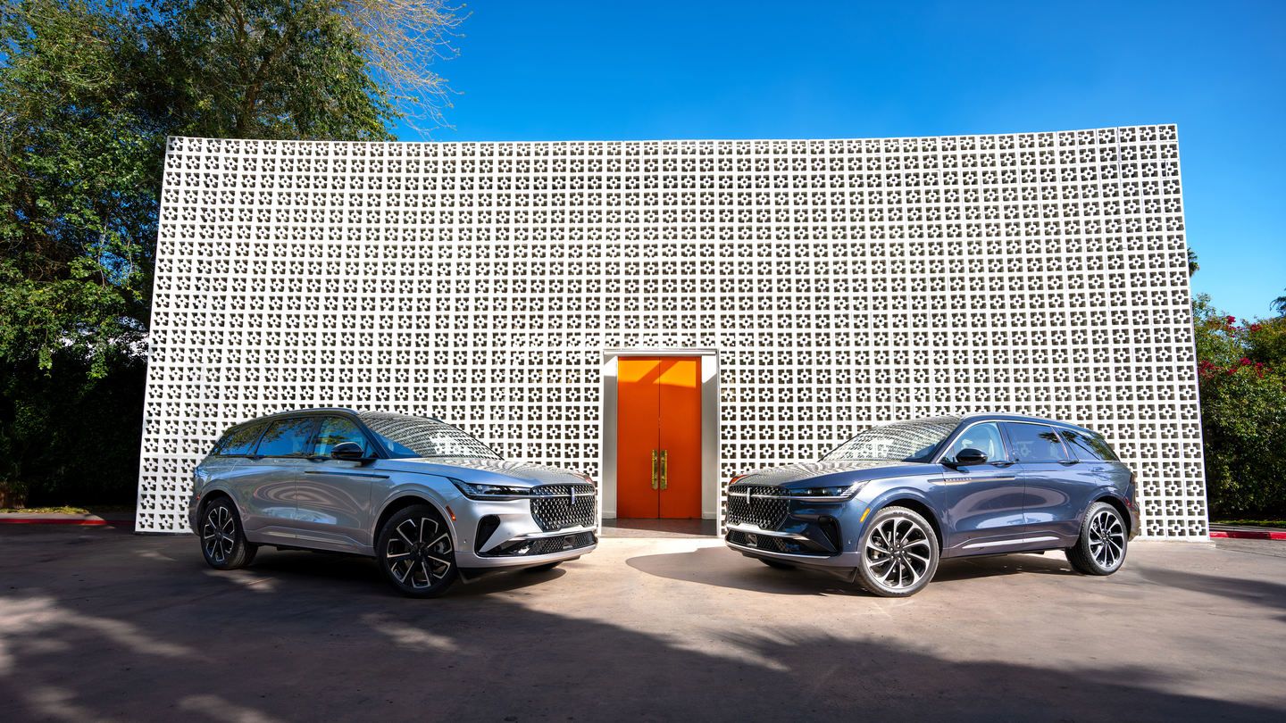 2026 Lincoln Nautilus - a silver and a blue 2026 Lincoln Nautilus parked in front of a modern building with an orange door - Bayfield Lincoln - New car dealership in Barrie, Ontario