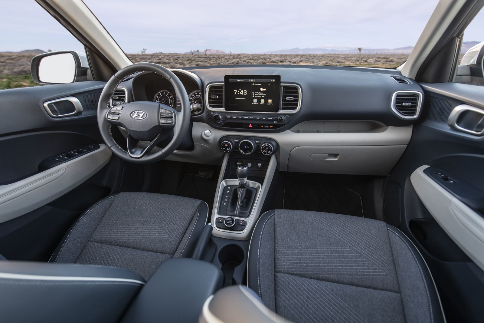 2026 Hyundai Venue - interior view of the front seats, steering wheel, and dashboard of a 2026 Hyundai Venue - Woodstock Hyundai - New car dealership in Woodstock, Ontario