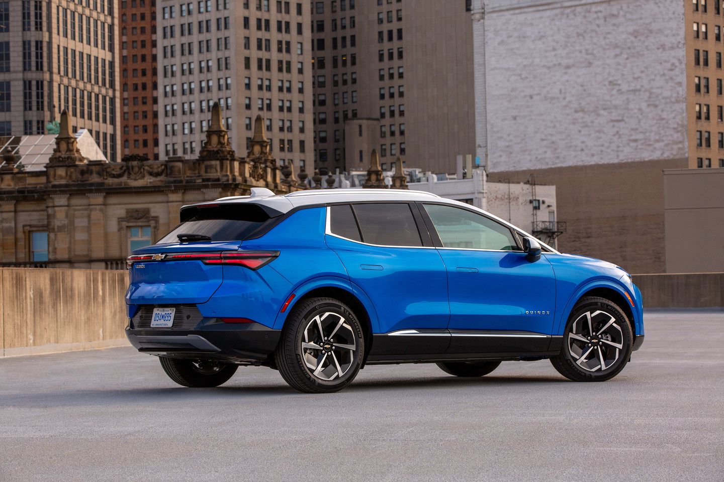 2026 Chevrolet Equinox EV - a blue 2026 Chevrolet Equinox EV with a white roof parked with city buildings in the background - Applewood Chevrolet, Buick, GMC - New car dealership in Mississauga, Ontario