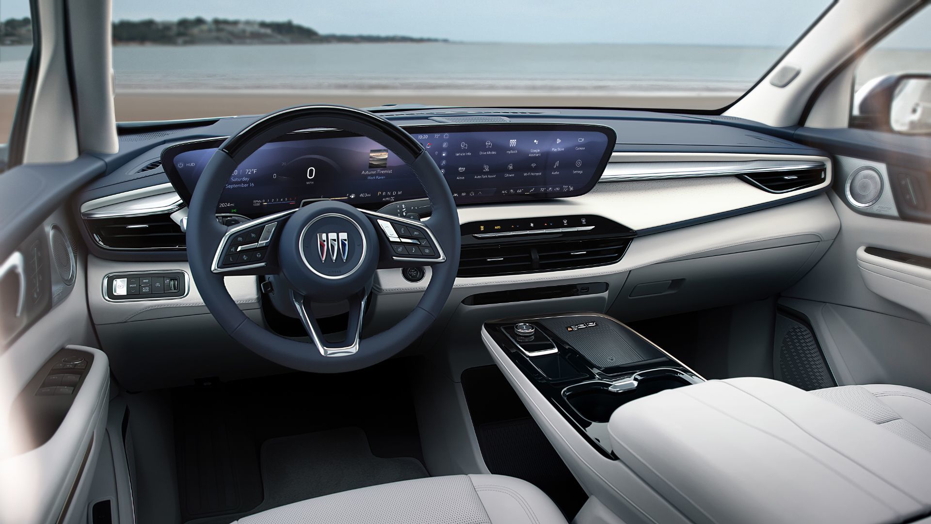 2026 Buick Enclave - Interior view focusing on the large digital dashboard display and a blue steering wheel with the Buick logo, overlooking a body of water - City Chevrolet, Buick, GMC - Buick new car dealership in Toronto, Ontario