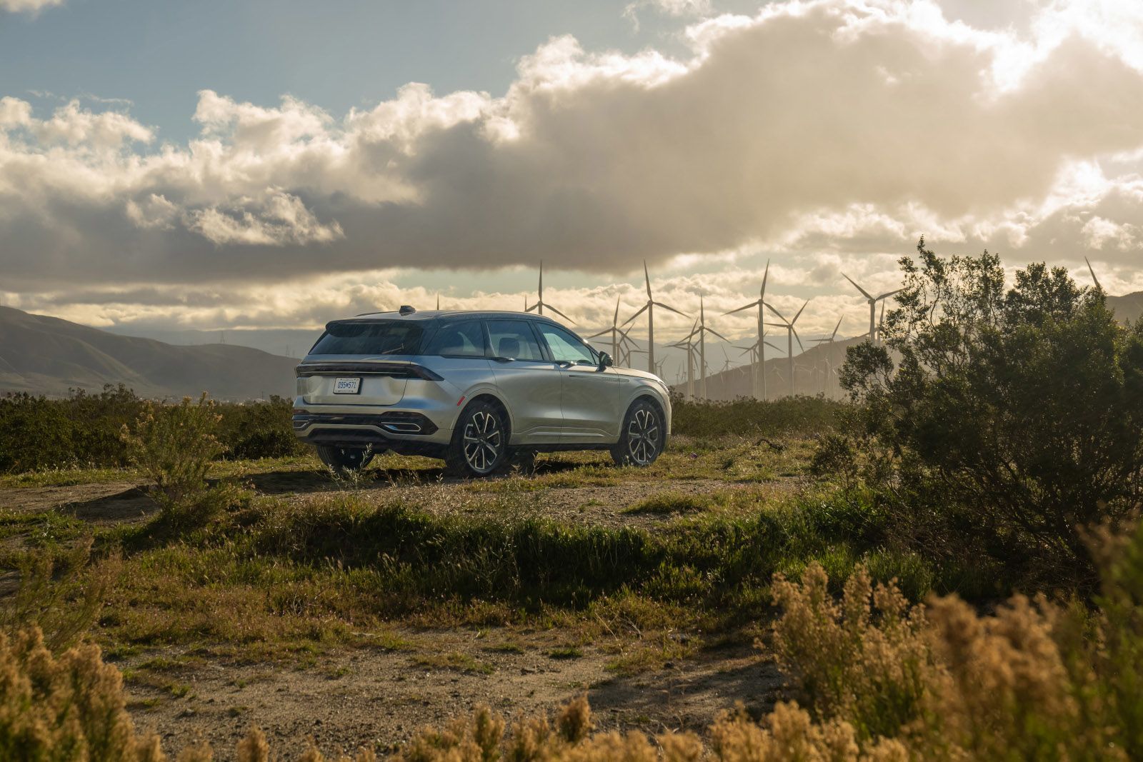 2026 Lincoln Nautilus - a silver 2026 Lincoln Nautilus parked in an open field with wind turbines - Bayfield Lincoln - Lincoln new car dealership in Barrie, Ontario