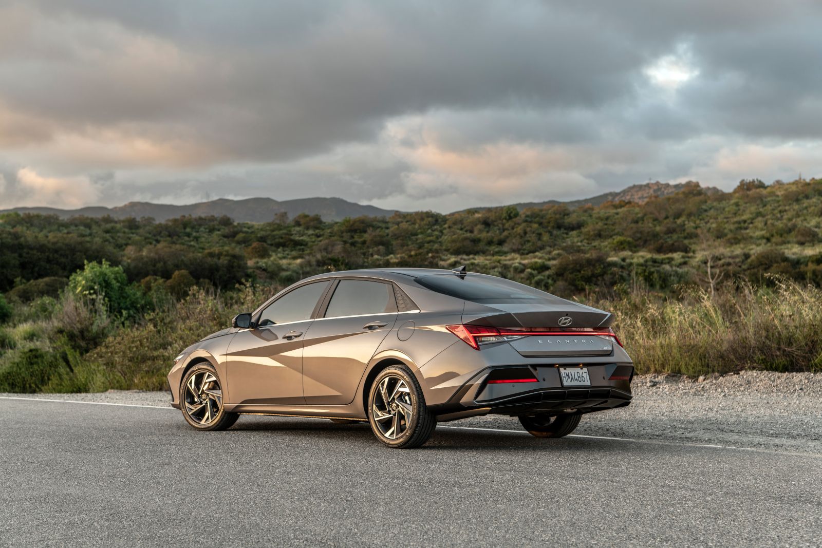 2026 Hyundai Elantra - rear three-quarter view of the 2026 Hyundai Elantra parked on an asphalt road at dusk - Cooksville Hyundai - Hyundai new car dealership in Mississauga, ON