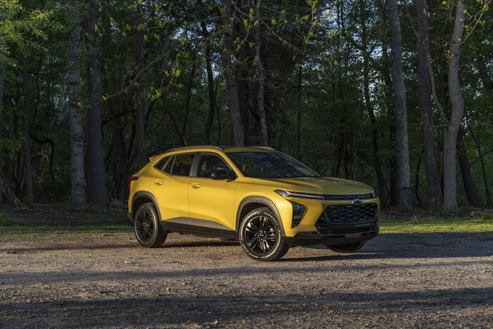 2026 Chevrolet Trax - three-quarter view of a yellow 2026 Chevrolet Trax parked on a dirt path with black wheels and tires - Applewood Chevrolet, Buick, GMC - New car dealership in Mississauga, Ontario