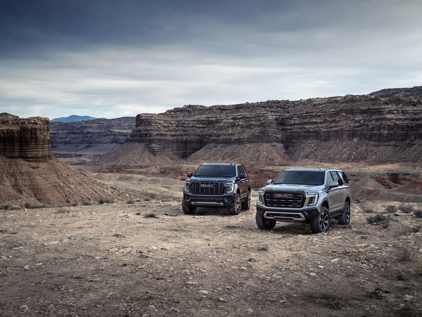 2026 GMC Yukon - A dark blue 2026 GMC Yukon and a silver 2026 GMC Yukon AT4 parked together in a desert canyon - Humberview Chevrolet, Buick, GMC - GMC car dealership in Toronto, Ontario