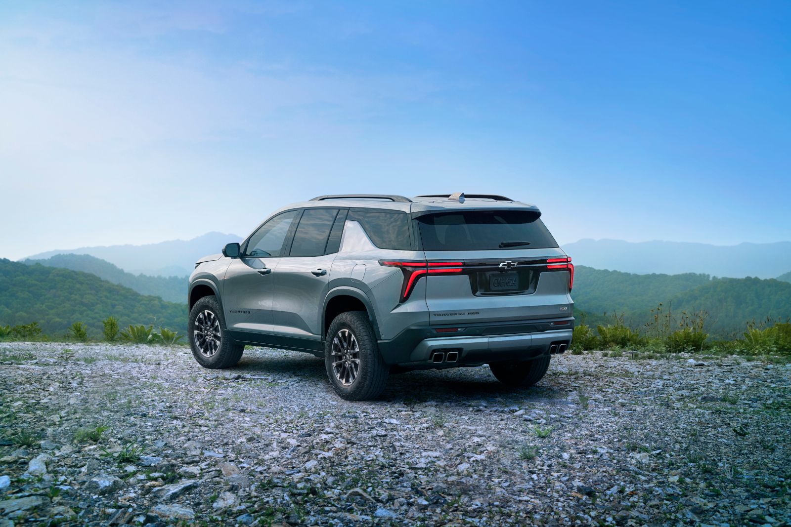 2027 Chevrolet Traverse - rear three-quarter view of a silver 2027 Chevrolet Traverse Z71 parked on a rocky mountain trail - City Chevrolet, Buick, GMC - New car dealership in Toronto, Ontario