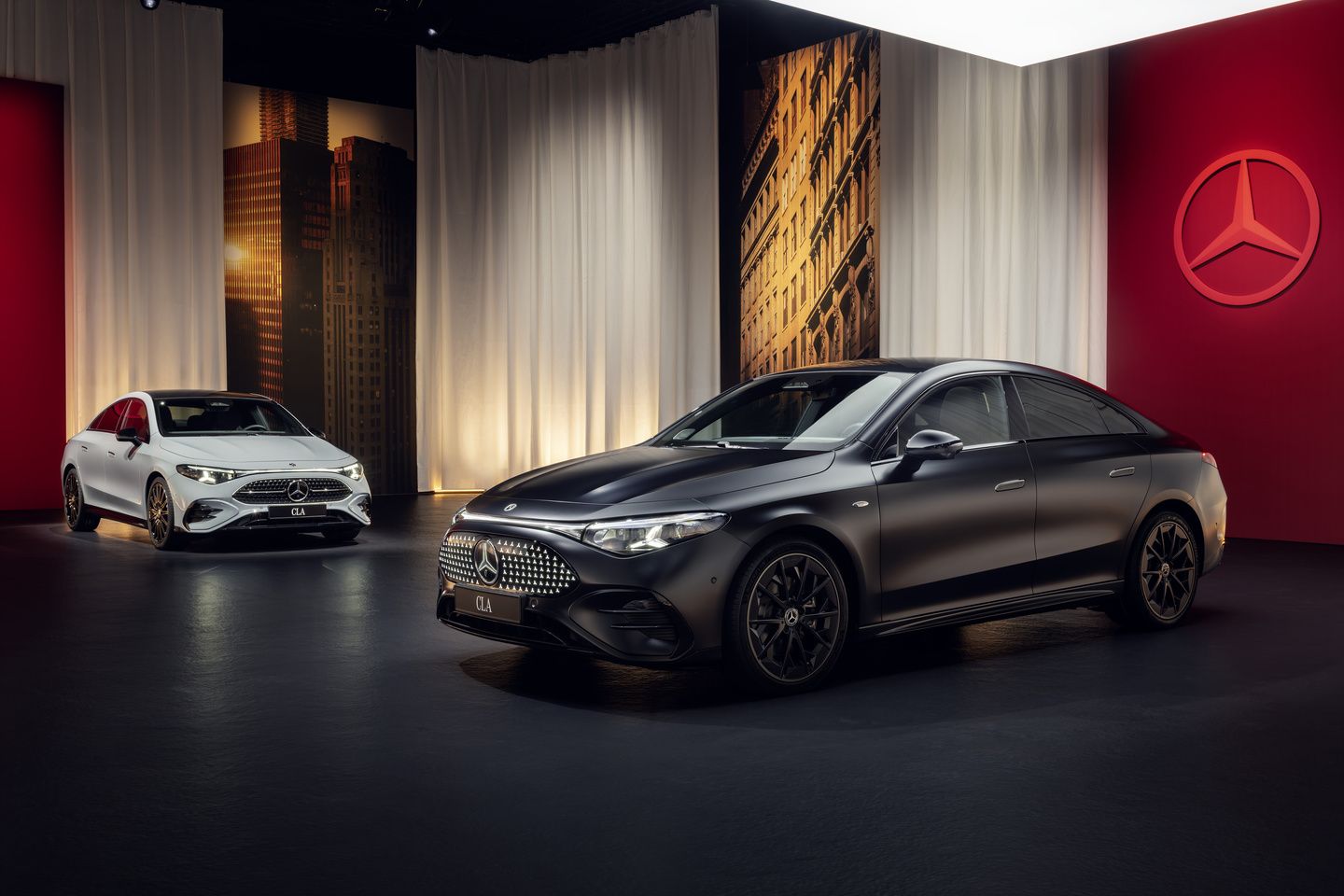 2027 Mercedes-Benz CLA - front three-quarter view of a black 2027 Mercedes-Benz CLA alongside a white CLA in an indoor showroom - Mercedes-Benz Brampton - Mercedes-Benz car dealership in Brampton, Ontario