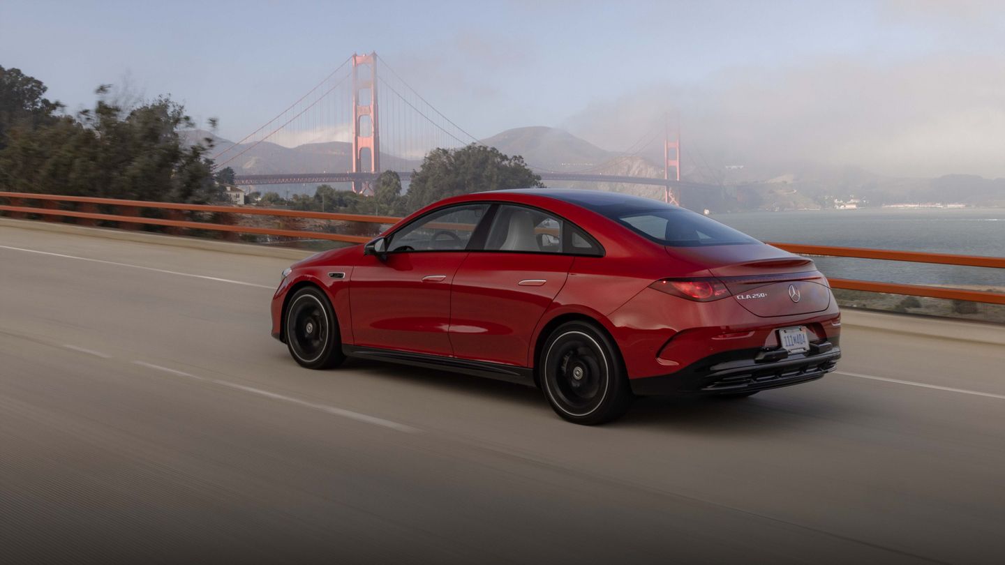 2027 Mercedes-Benz CLA - rear side view of a red 2027 Mercedes-Benz CLA driving on a bridge with the Golden Gate Bridge in the background - Mercedes-Benz Brampton - Mercedes-Benz car dealership in Brampton, Ontario