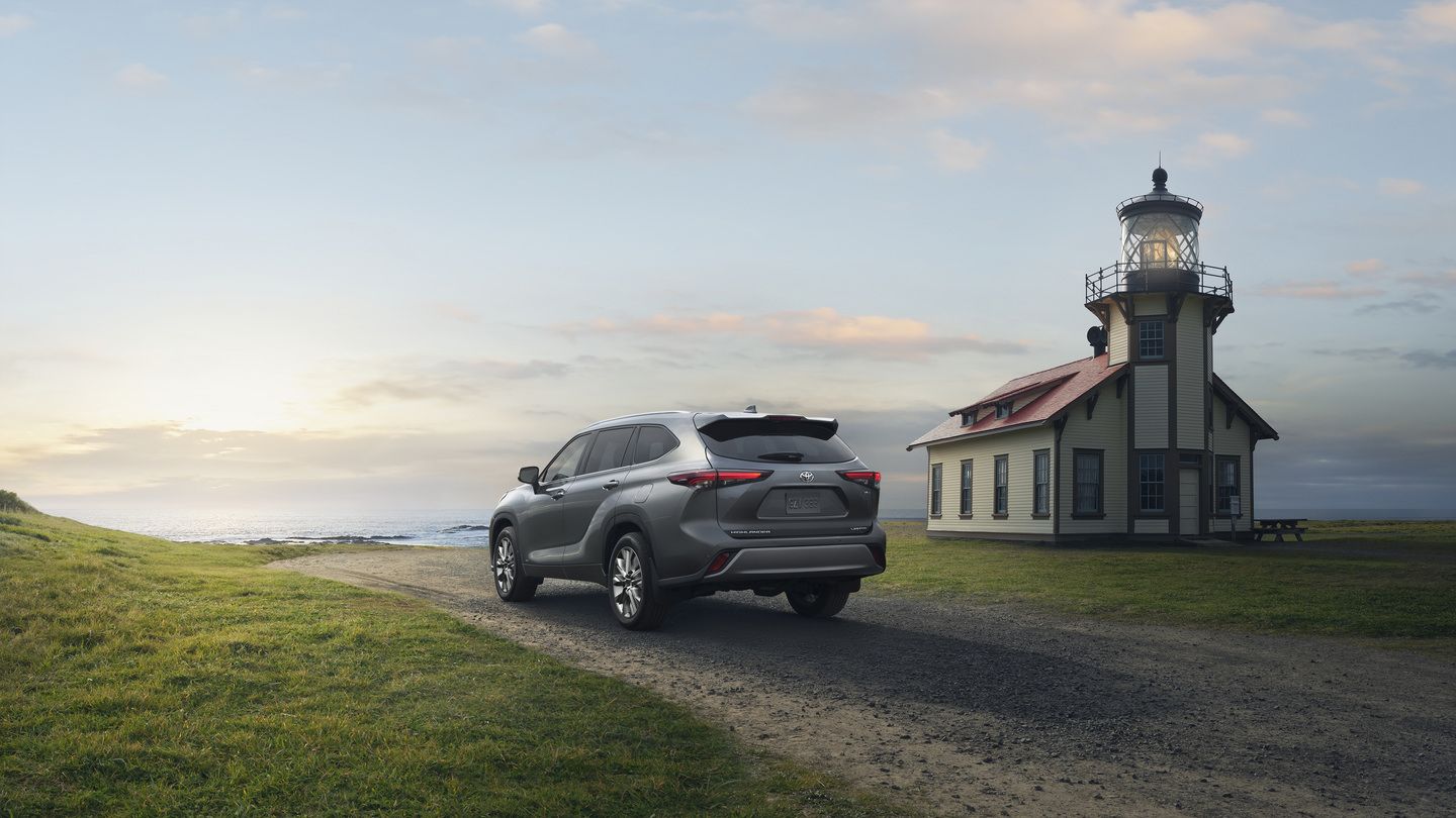 Toyota Highlander - rear view of a silver Toyota Highlander driving on a coastal dirt road near a lighthouse at sunset - Oakville Toyota - Toyota car dealership in Oakville, Ontario