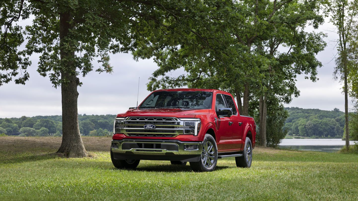 2027 Ford F-150 - front three-quarter view of a red 2027 Ford F-150 parked on grass near a lake - Humberview Group - New car dealerships in Ontario