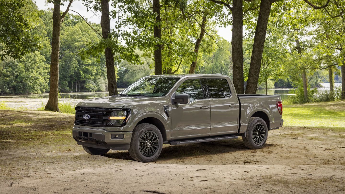 2027 Ford F-150 - side three-quarter profile of a grey 2027 Ford F-150 parked on dirt by trees - Humberview Group - New car dealerships in Ontario