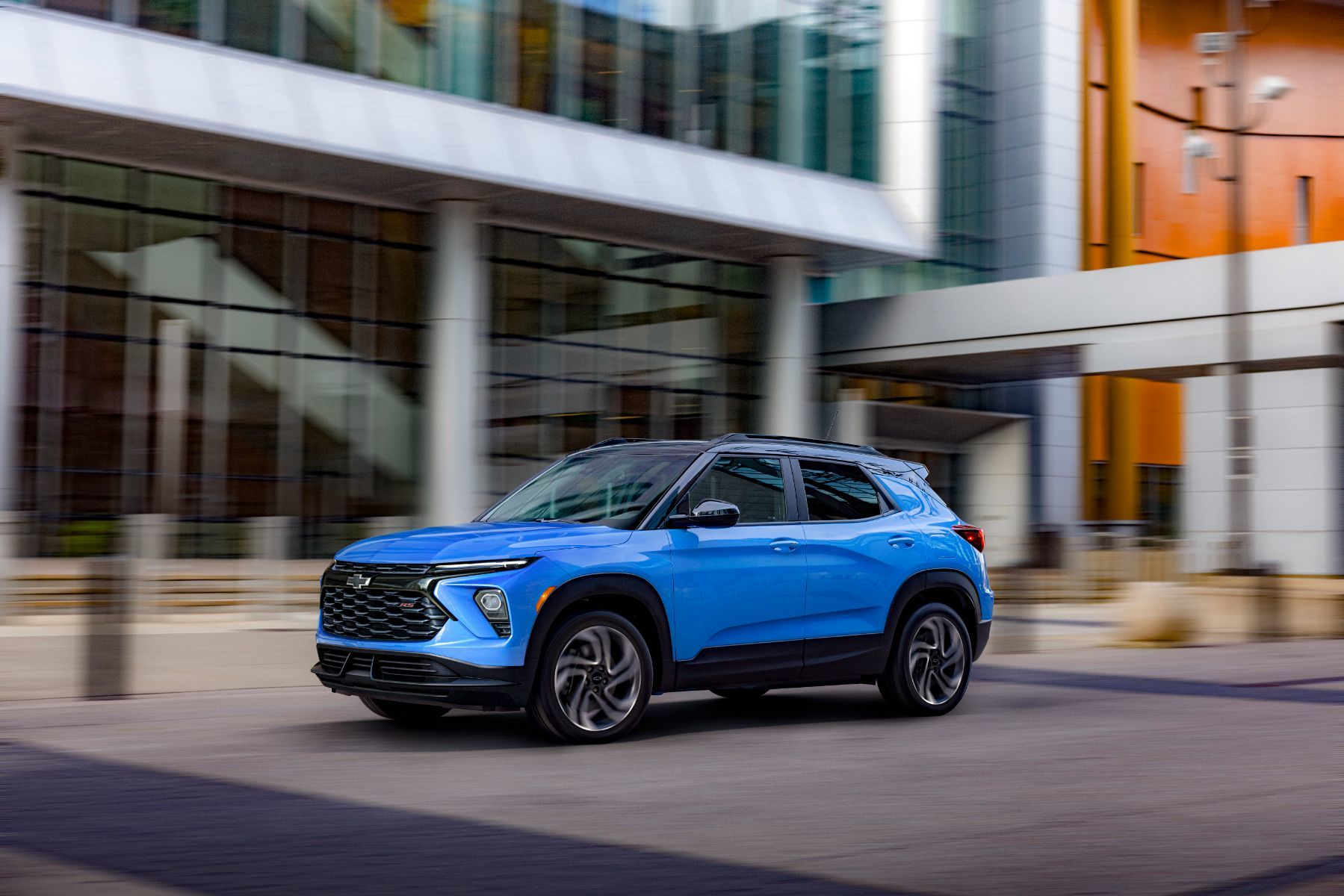 2027 Chevrolet Trailblazer - a 3/4 front view of a blue 2027 Chevrolet Trailblazer driving on a street with modern buildings - Applewood Chevrolet, Buick, GMC - Chevrolet car dealership in Mississauga, Ontario