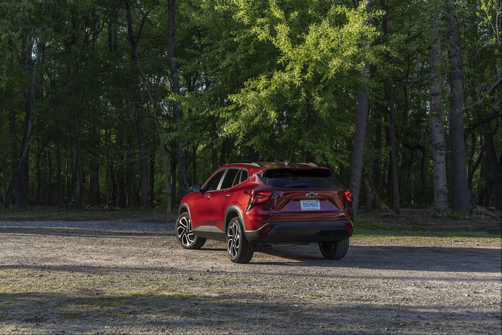 2027 Chevrolet Trax - a rear view of a red 2027 Chevrolet Trax on a gravel road with trees in the background - Applewood Chevrolet, Buick, GMC - Chevrolet car dealership in Mississauga, Ontario