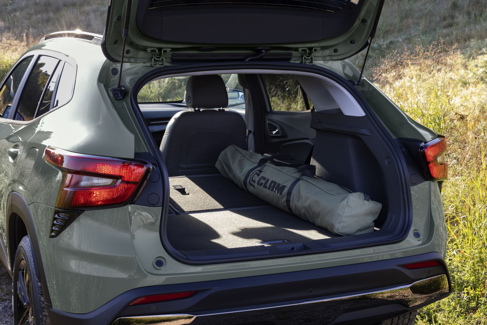 2027 Chevrolet Trax - a green 2027 Chevrolet Trax with the rear hatch open, showing a rolled-up tent in the cargo area - City Chevrolet Buick GMC - New car dealership in Toronto, Ontario