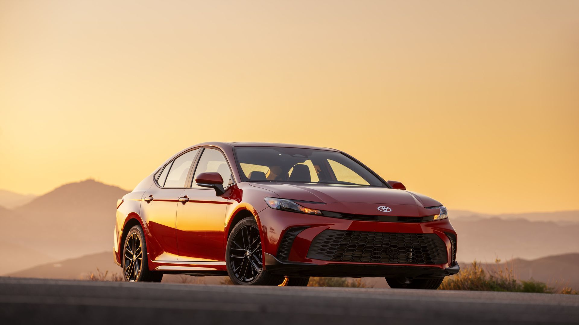 2027 Toyota Camry - front three-quarter view of a red 2027 Toyota Camry at sunset - Georgetown Toyota - Toyota car dealership in Georgetown, Ontario