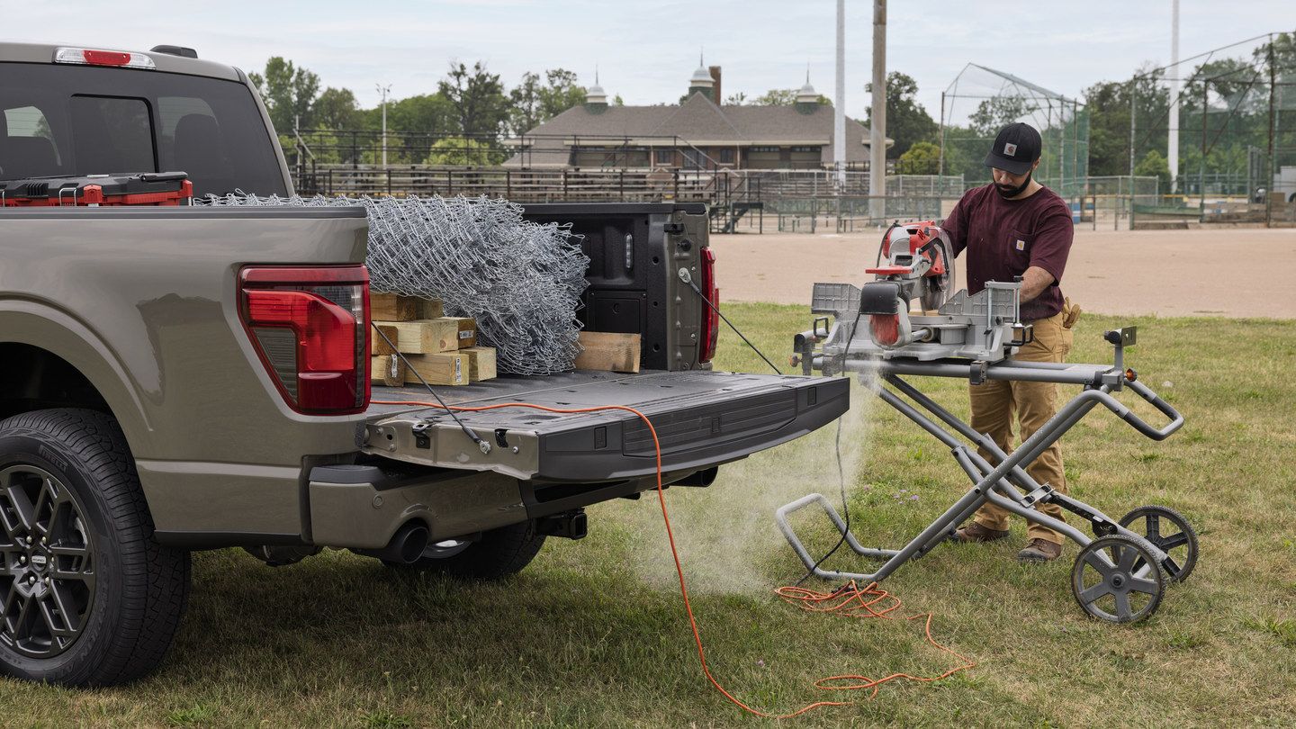 2027 Ford F-150 - open tailgate and truck bed of a Ford F-150 powering job site equipment - Mayfield Ford - New car dealership in Brampton, Ontario