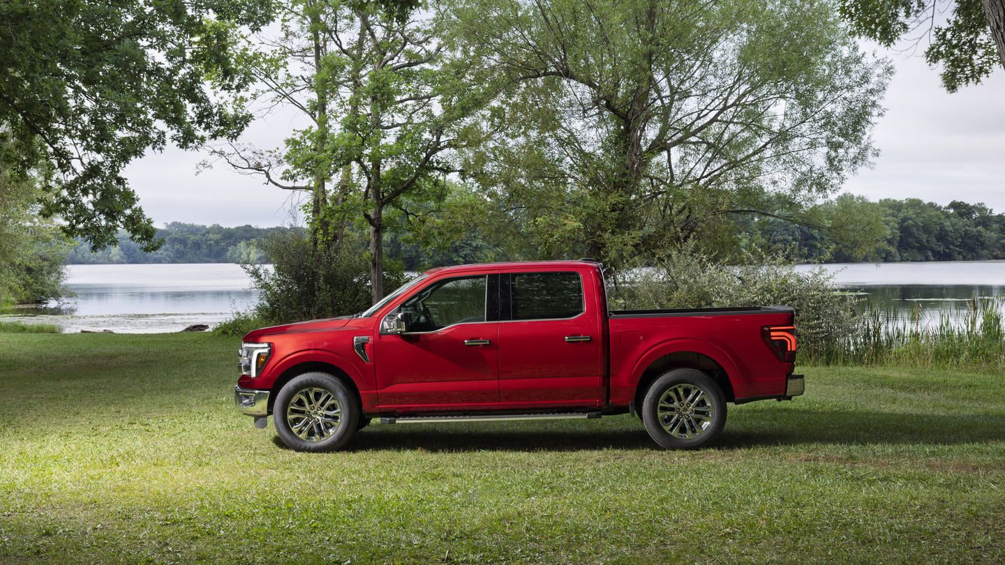 2027 Ford F-150 - side profile view of a red Ford F-150 parked on grass near a lake - Mayfield Ford - New car dealership in Brampton, Ontario