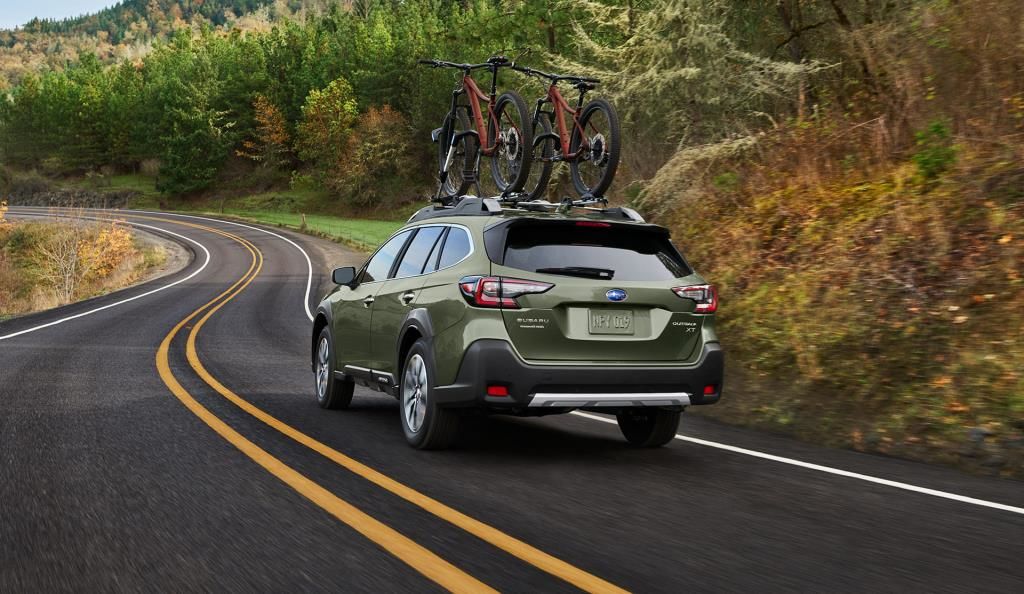 vue latérale arrière d'une Subaru Outback 2023 sur une route de montagne