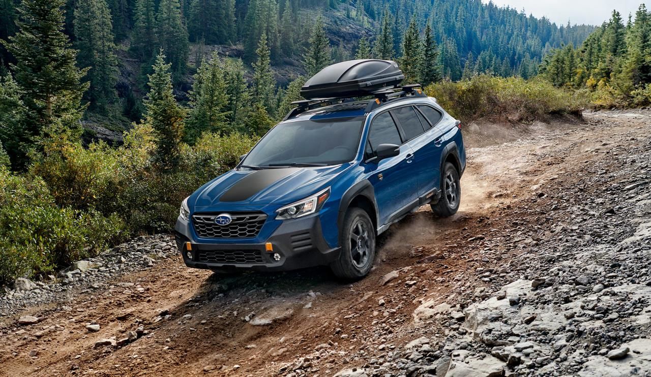 vue latérale avant d'une Subaru Outback 2023 qui circule sur un sentir non pavé