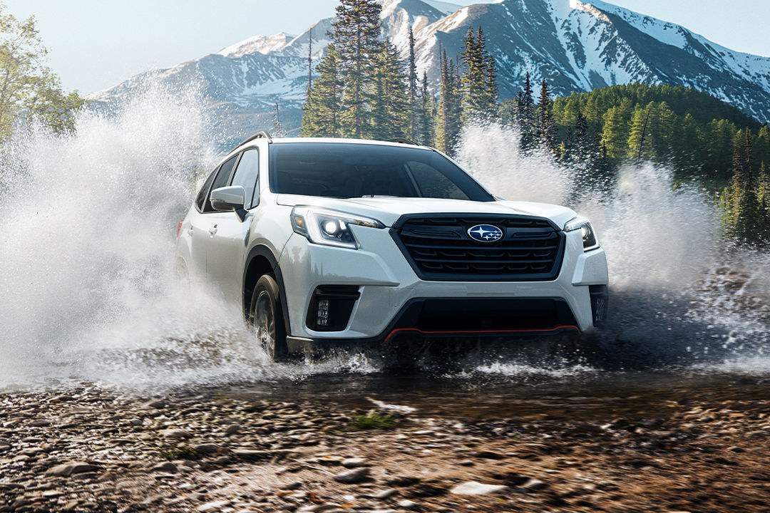 Vue avant du Subaru Forester 2024 traversant une marre d'eau en bas d'une montagne