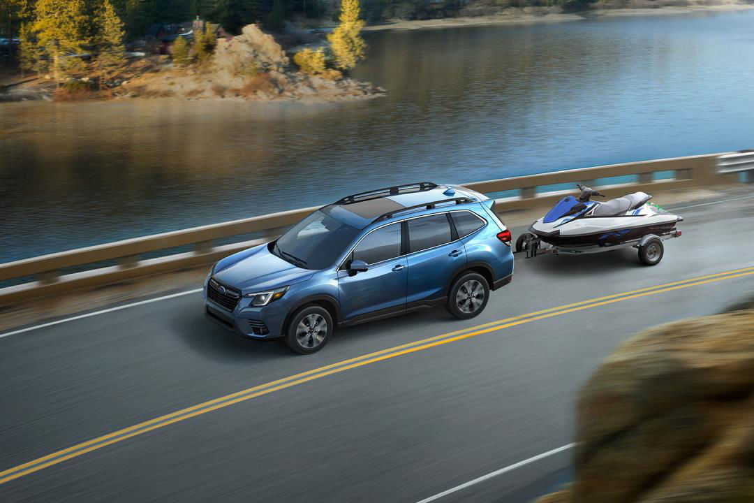 Vue de côté du Subaru Forester 2023 sur route avec chargement d'un bateau