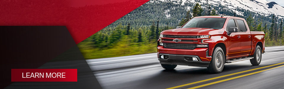 learn more: image of a red pickup on a wet road