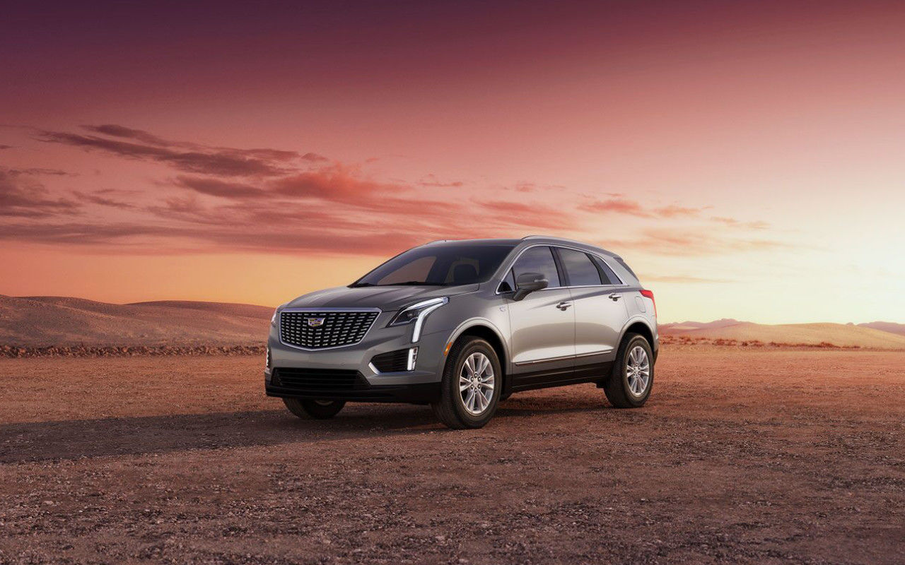 front side view of a 2023 Cadillac XT5 in a desert at dusk