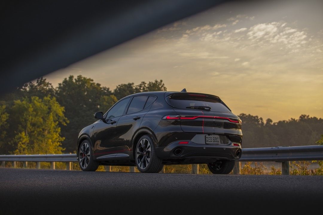 side rear view of a 2023 Dodge Hornet on a country road at sunset