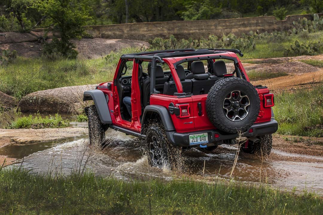 side rear view of a 2022 Jeep Wrangler crossing a puddle