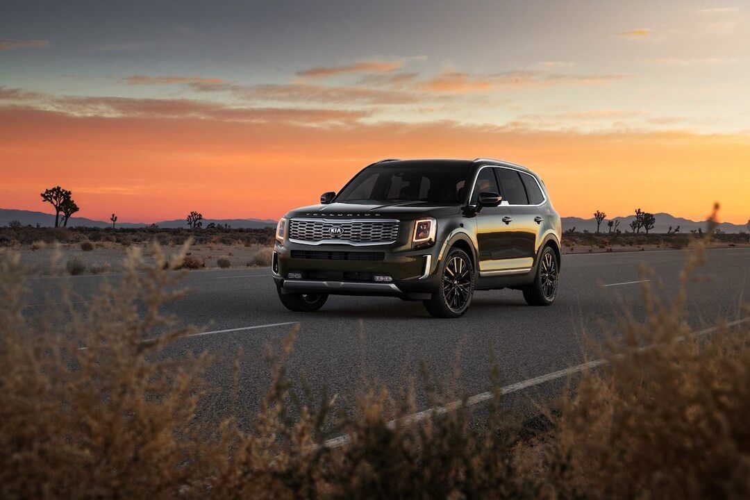 frontal side view of a Kia Telluride on the road at sunset