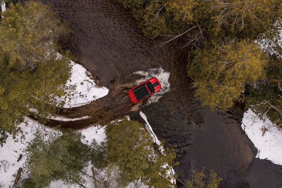 vue à vol d'oiseau d'un Jeep Renegade 2022 qui traverse une rivière