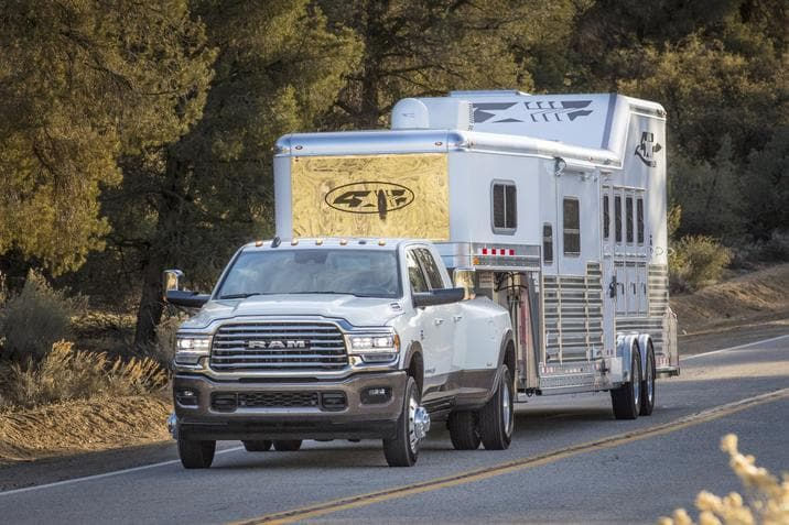 front side view of a 2020 RAM 1500 carrying a 5th wheel on a country road