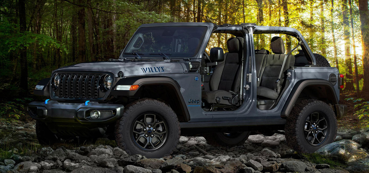 Front 3/4 front and side view of the Jeep Wrangler hybrid 4xe 2024 on a steep forest road