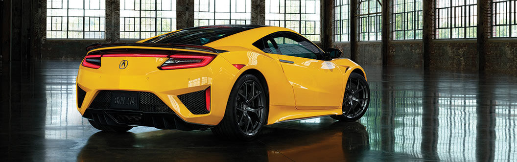 rear of a 2021 yellow acura nsx in warehouse
