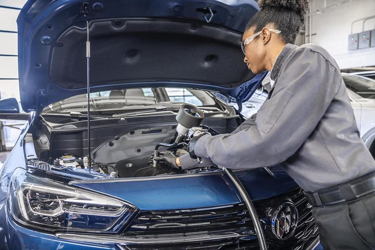 Technician servicing a Chevrolet engine bay to illustrate when to schedule an oil change.
