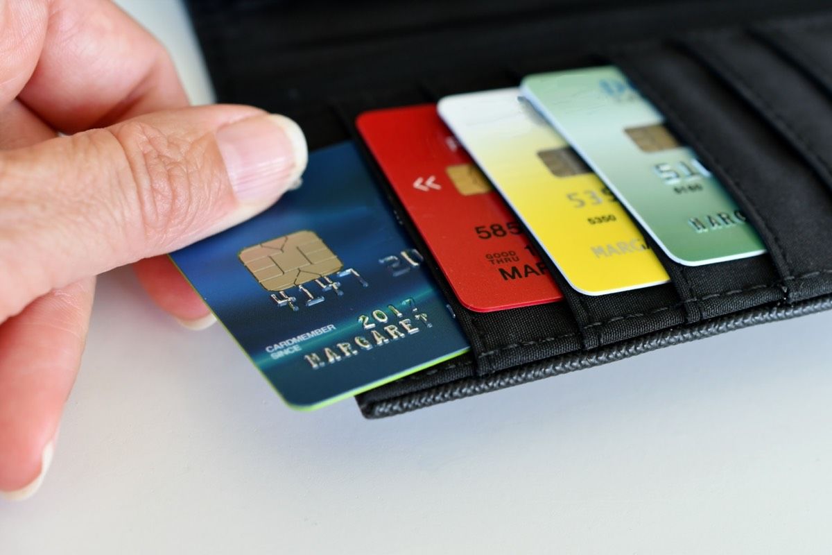 A hand taking out a credit card from a wallet for credit score