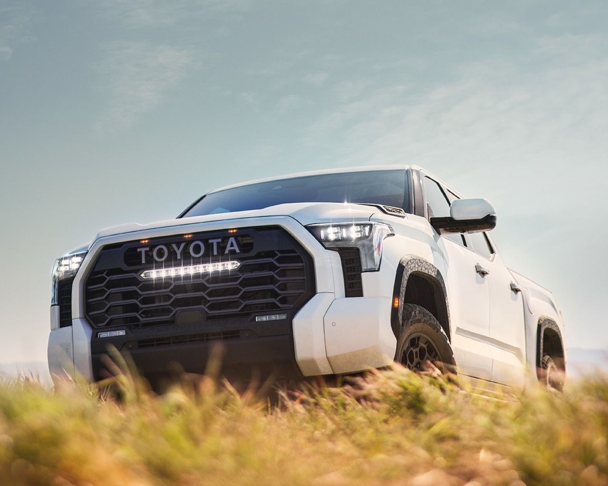 Ground and front 3/4 view of a white 2022 Toyota Tundra TRD Pro parked in a field outside
