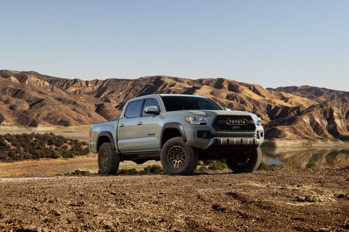 Front 3/4 view of the 2022 Toyota Tacoma Trail parked in a desert with a mountain range in the background