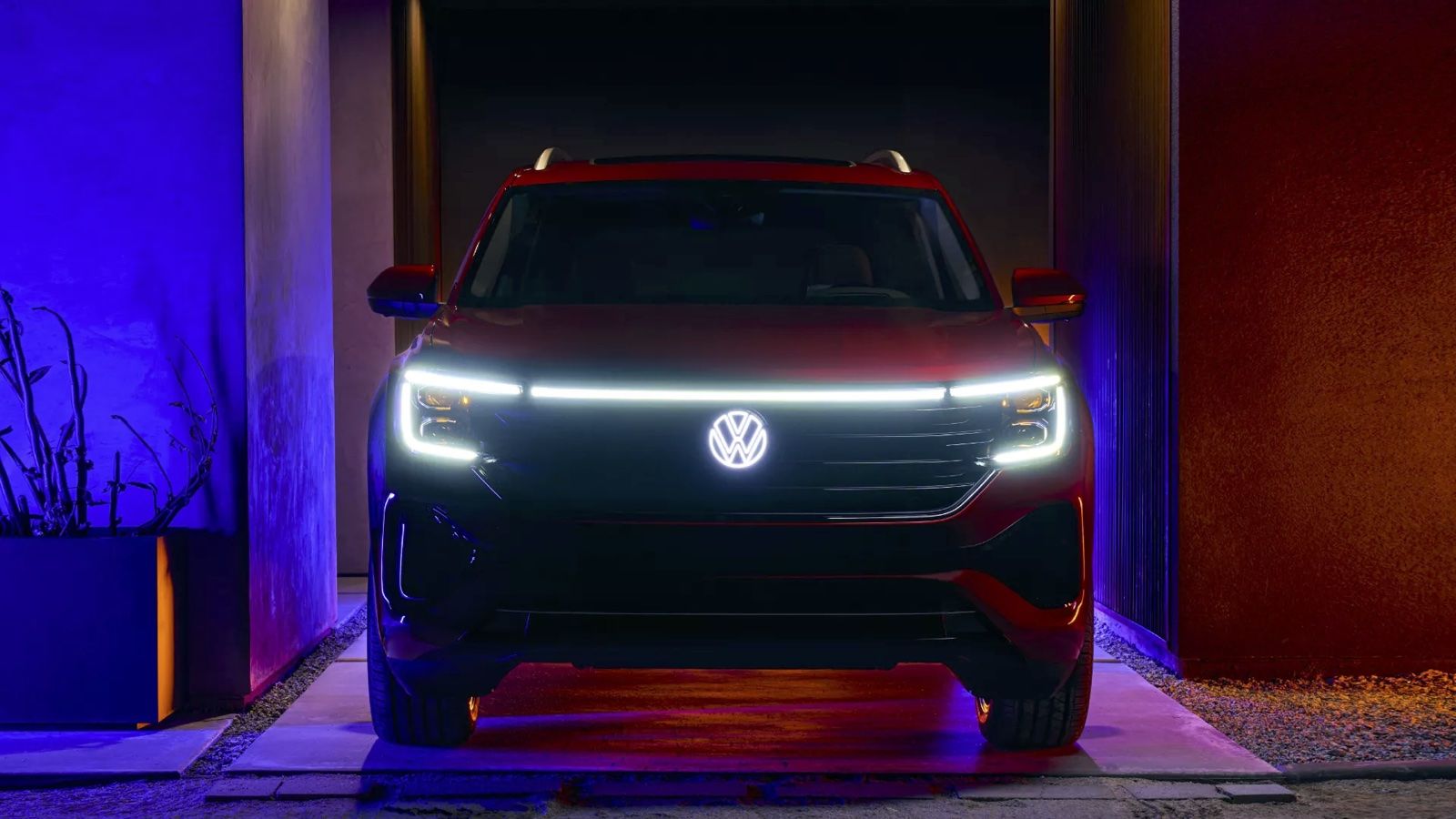 Front view of Volkswagen Atlas 2024 parked in front of a residence with lights on.