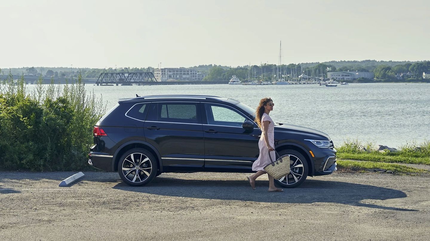 A lady who has just parked her Volkswagen Tiguan 2024 at the water's edge.