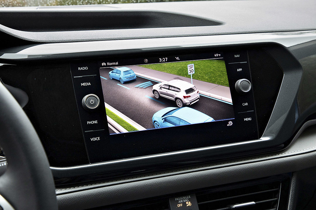 view of the touchscreen and of one of the driver-assist feature available inside of the 2022 Volkswagen Taos