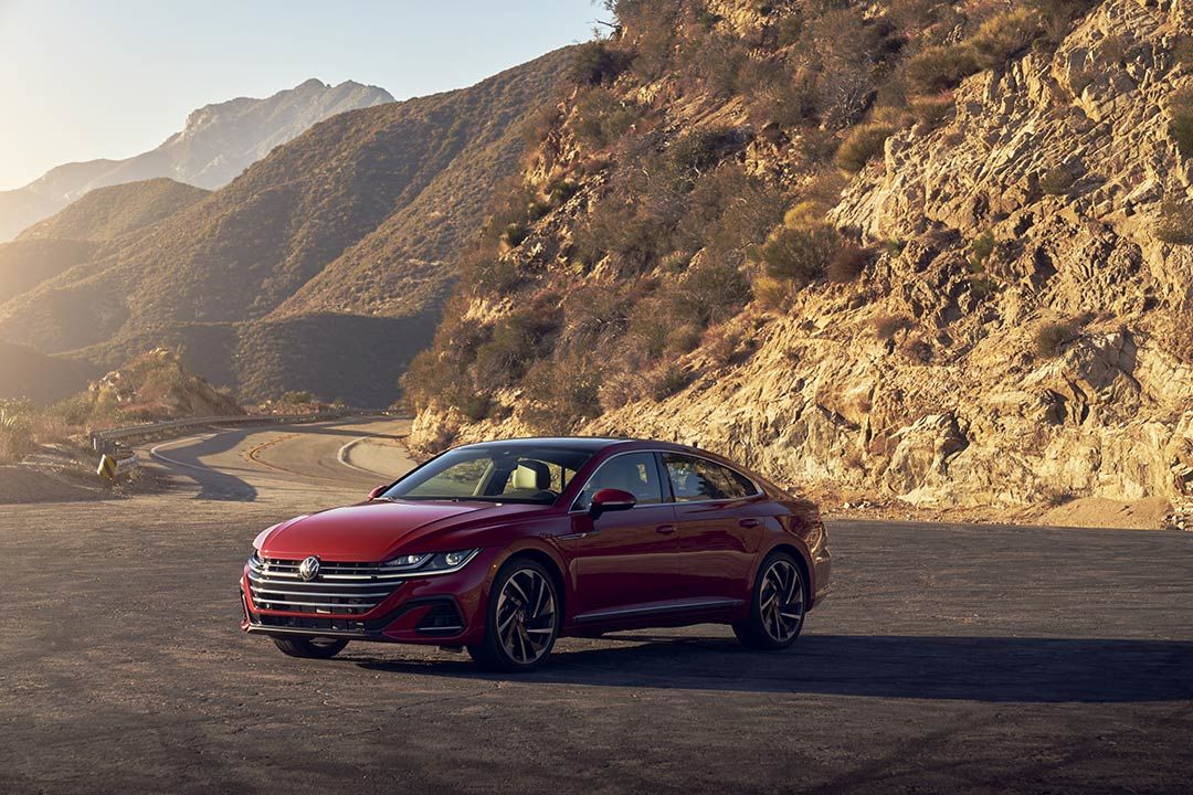 three quarter front view of the 2021 Volkswagen Arteon parked close to a mountain range