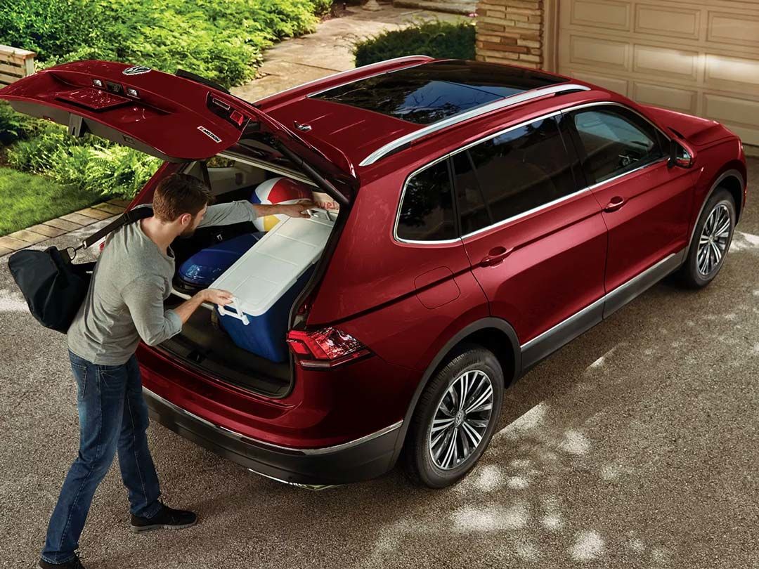 rear view of the 2021 Volkswagen Tiguan with the trunk open while it is being loaded