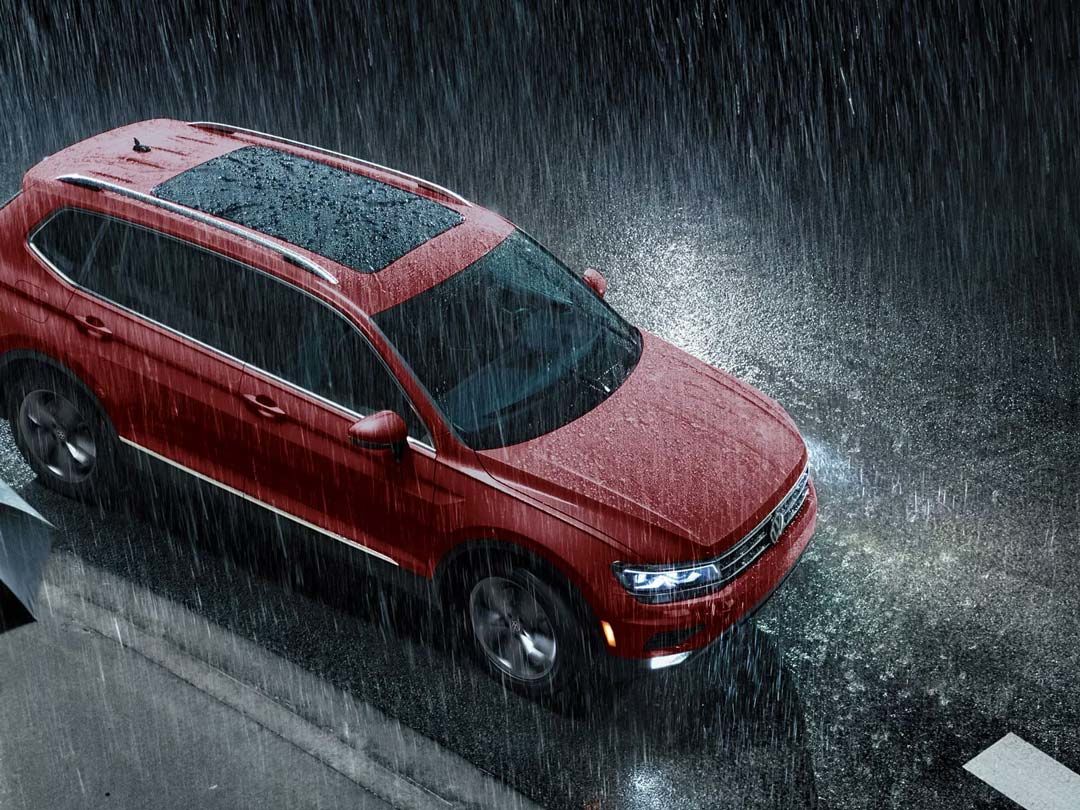 three quarter view of the 2021 Volkswagen Tiguan driven on a road while it is raining