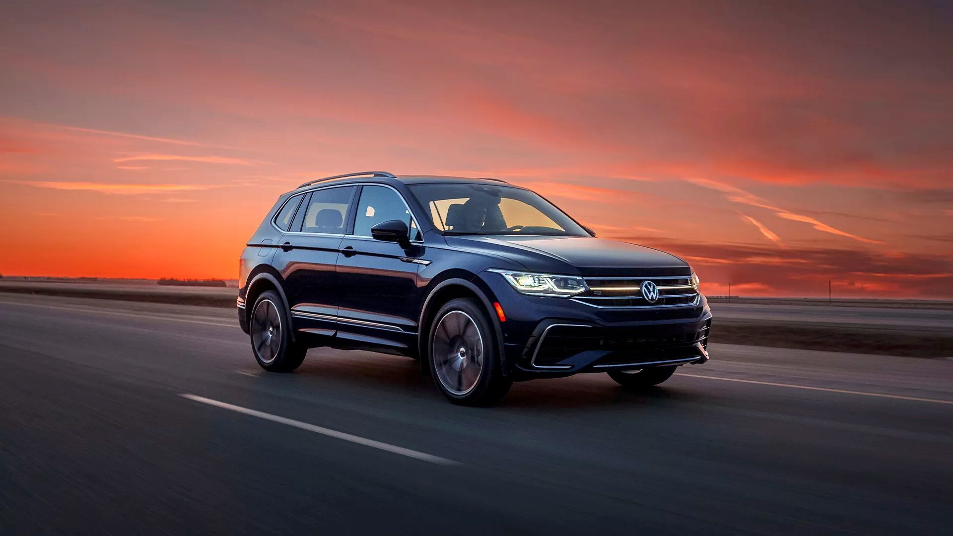 The Volkswagen Tiguan 2024 driving down the freeway at sunset.