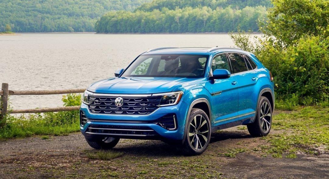 The Volkswagen Atlas 2024 parked by a lake under the trees.