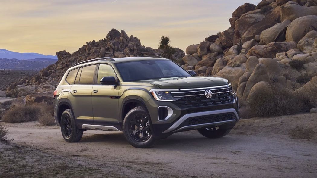 Front 3/4 view of 2024 Volkswagen Atlas parked on a sand road.