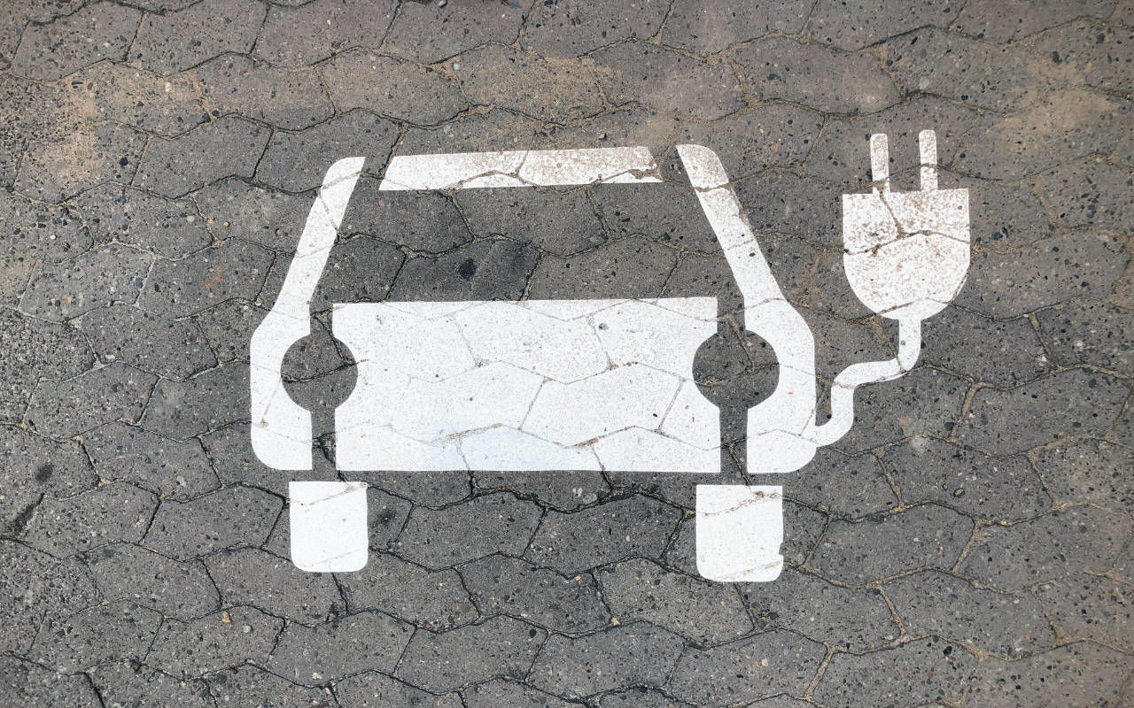 close-up view of an EV charging logo in white paint on the ground