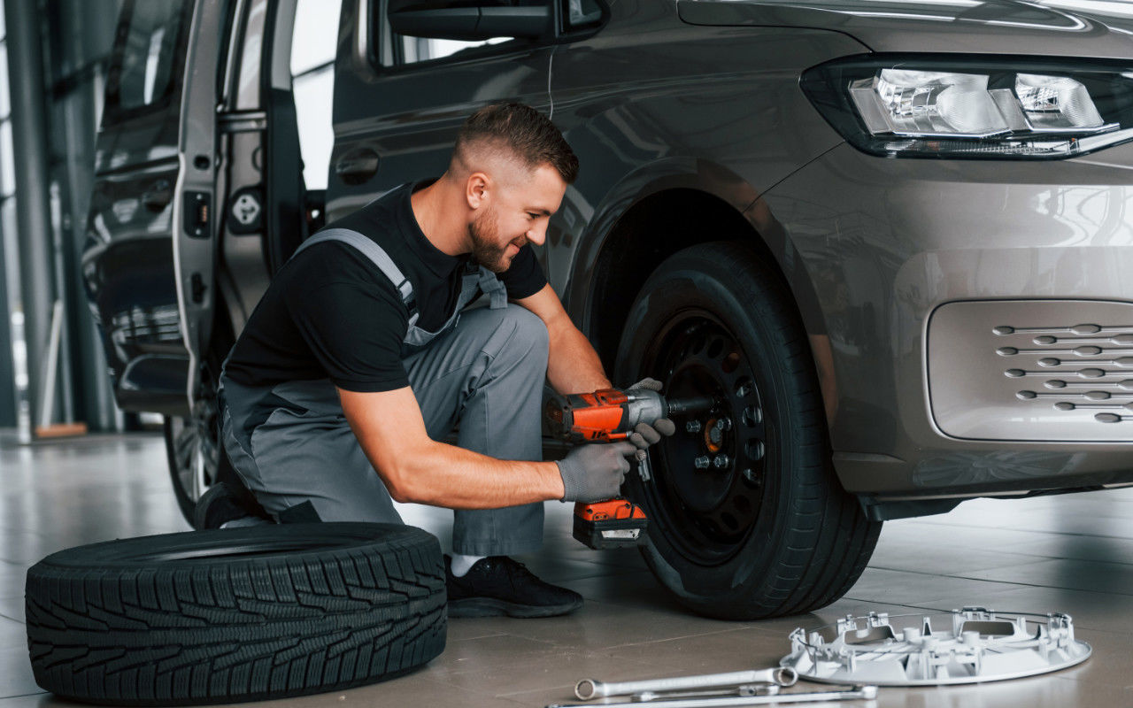 mechanic installing winter tires on a vehicles