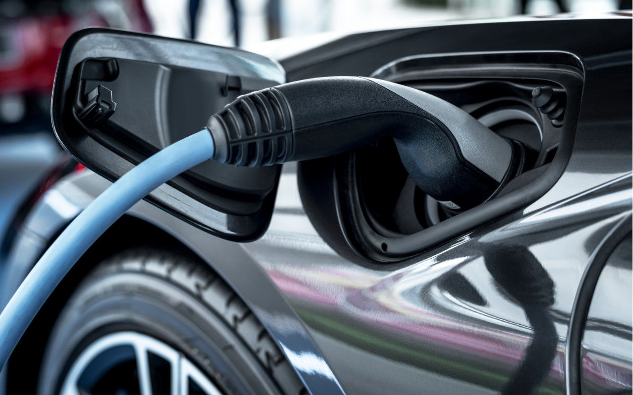 close up view of an electric vehicle plugged in a charging station